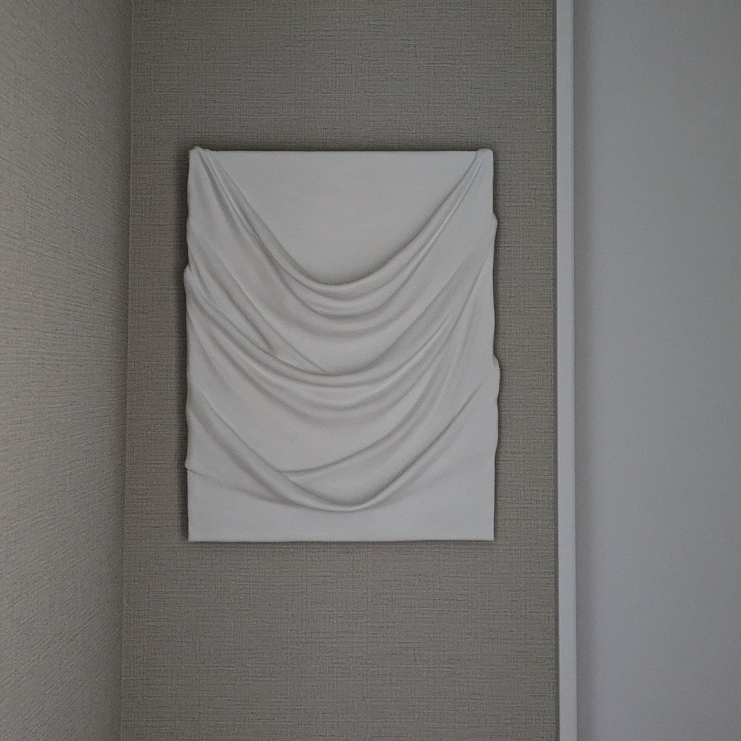 白のドレープが幾重にも重なり、やわらかな陰影を生む一点ものの立体アート