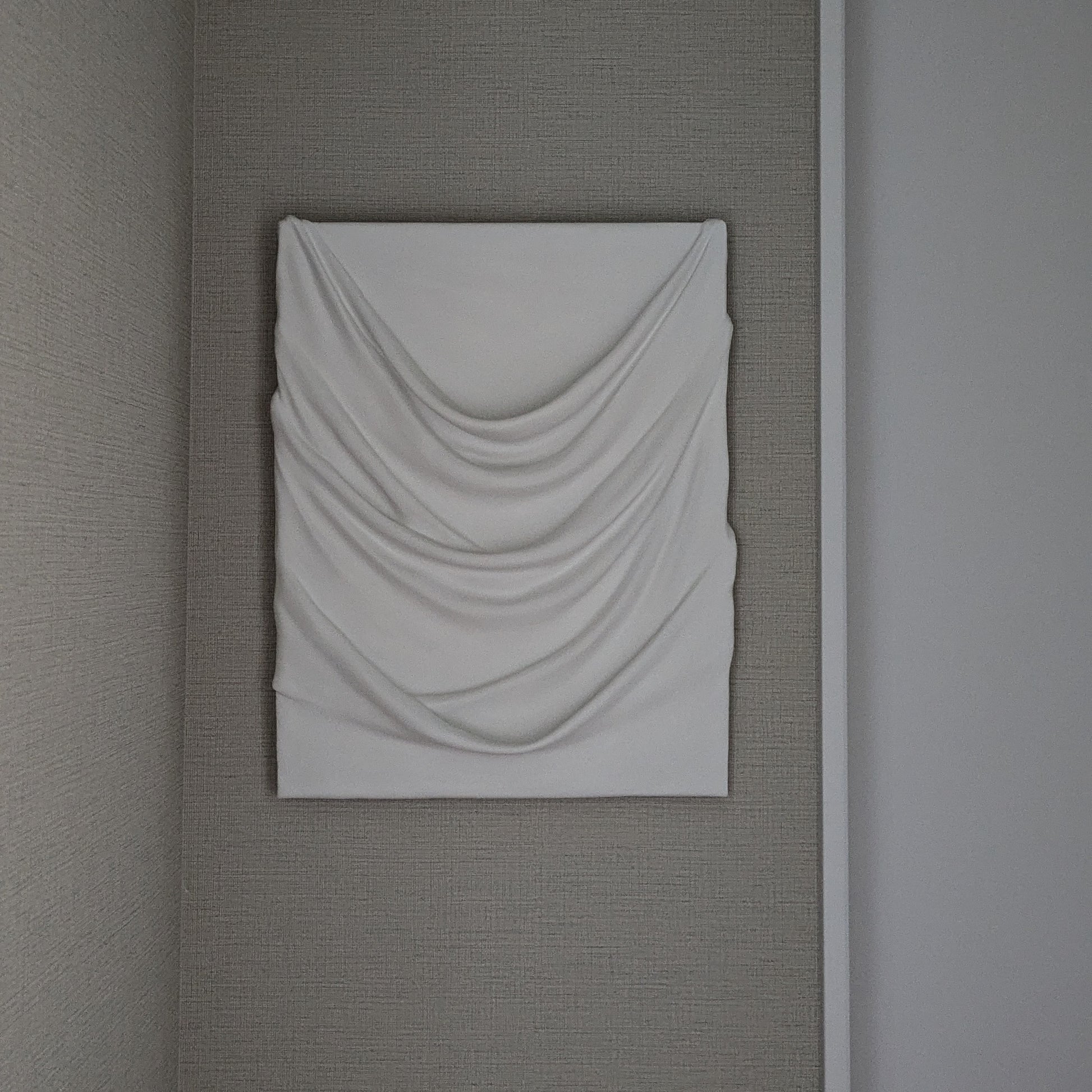 白のドレープが幾重にも重なり、やわらかな陰影を生む一点ものの立体アート