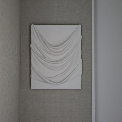 白のドレープが幾重にも重なり、やわらかな陰影を生む一点ものの立体アート